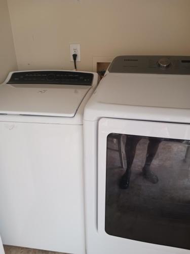 Una lavadora blanca con la puerta abierta en una habitación en Cozy Self-contained Bedroom, en Jonesboro