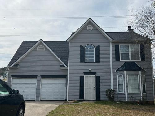 una casa con un coche aparcado delante en Cozy Self-contained Bedroom, en Jonesboro
