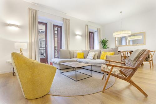 sala de estar con sofá, mesa y sillas en Cibeles Luxe in Madrid, en Madrid