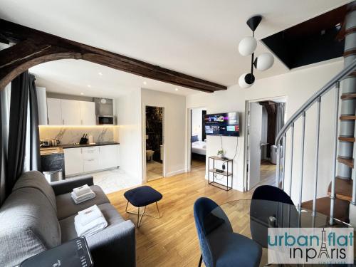 un salon avec un canapé et des chaises et une cuisine dans l'établissement Urban Flat 176 - Charming 3 Bedroom in Montorgueil, à Paris