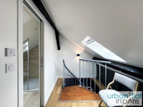 - un escalier dans une maison avec une lucarne dans l'établissement Urban Flat 176 - Charming 3 Bedroom in Montorgueil, à Paris