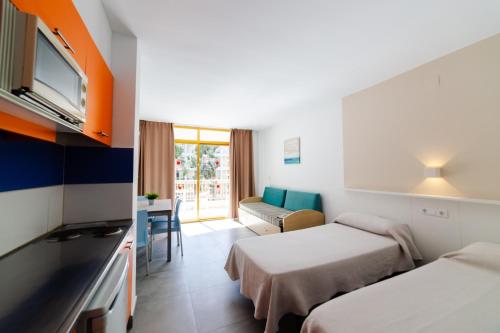 une chambre d'hôtel avec deux lits et un canapé dans l'établissement Inter 2, à Salou