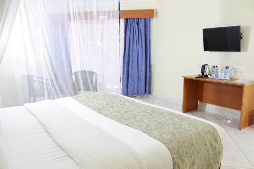 Ένα ή περισσότερα κρεβάτια σε δωμάτιο στο IZAAK WALTON INN Embu