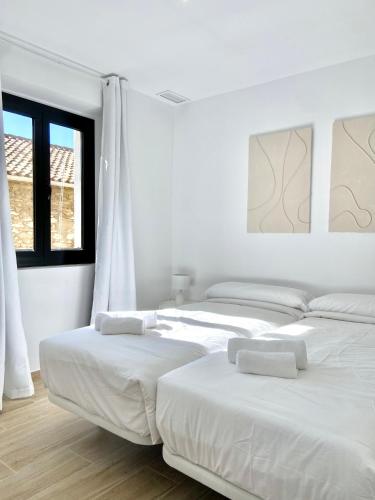 塔拉戈纳Vigablanca Apartments的一间白墙房间里有两张床