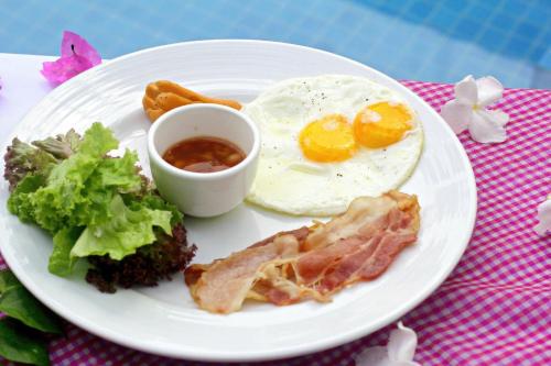 a plate of breakfast food with eggs bacon and vegetables at The Calm Oasis in Siem Reap