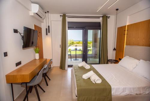 a hotel room with a bed and a desk and a table at Fyllis Fine Living Sea view in Asprovalta