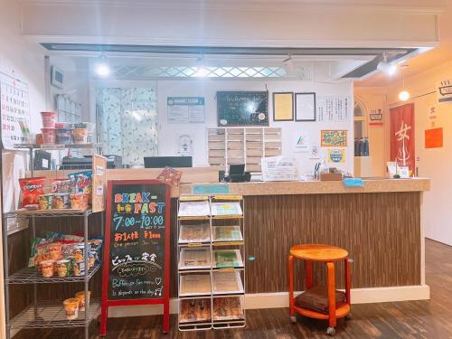 a store with a counter and a stool in a room at Karuizawa Pension Sato no Nukumori in Karuizawa