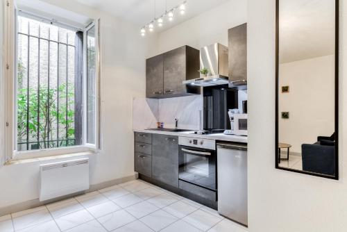 d'une cuisine équipée d'appareils en acier inoxydable et d'une fenêtre. dans l'établissement Le Jacques - Proche centre - RDC - Netflix, à Carcassonne