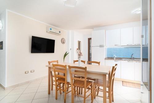 a kitchen and dining room with a table and chairs at Casa Vacanza Cala Biriala in Orosei