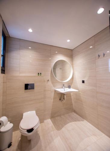 a bathroom with a toilet and a sink and a mirror at Fyllis Fine Living Sea view in Asprovalta