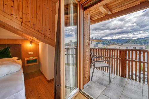 Habitación con cama y balcón con vistas. en Chalet Schlossberg Weißhorn en Nova Ponente