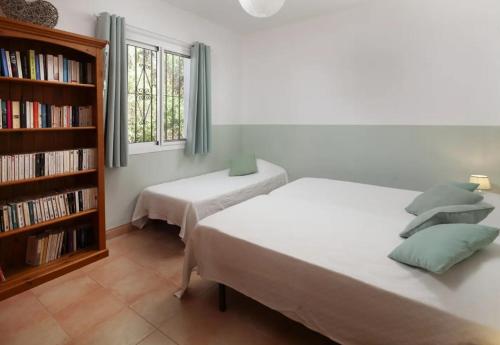een slaapkamer met 2 bedden en een boekenplank bij Casa Mañana, 365-Rentals in Torrox