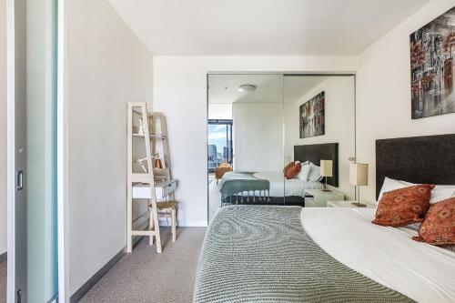 a bedroom with a bed and a mirror at Skyline Allure - Urban Wellness meets City Living in Melbourne