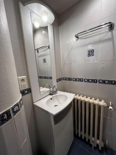 une salle de bain avec un lavabo, un miroir et un radiateur dans l'établissement #Le Capitaine - Proche Stadium -F2 Rez-de-chaussee, à Brive-la-Gaillarde