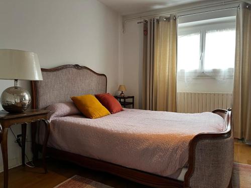 une chambre avec un lit avec deux oreillers dessus dans l'établissement #Le Capitaine - Proche Stadium -F2 Rez-de-chaussee, à Brive-la-Gaillarde