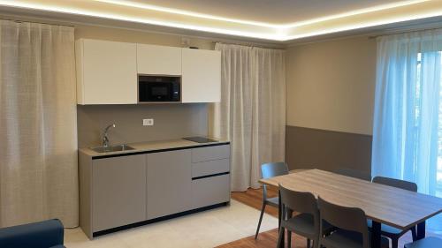 uma cozinha e sala de jantar com mesa e cadeiras em Sporthotel Olimpo em Garda