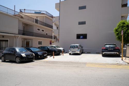 a group of cars parked in a parking lot next to a building at Palatino Hotel in Zakynthos Town