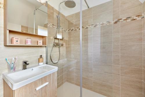 une salle de bain avec douche et lavabo dans l'établissement Au bon repos - Appt proche de la mer, à Cabourg