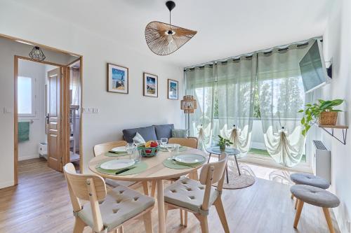 une salle à manger et un salon avec une table et des chaises dans l'établissement Au bon repos - Appt proche de la mer, à Cabourg