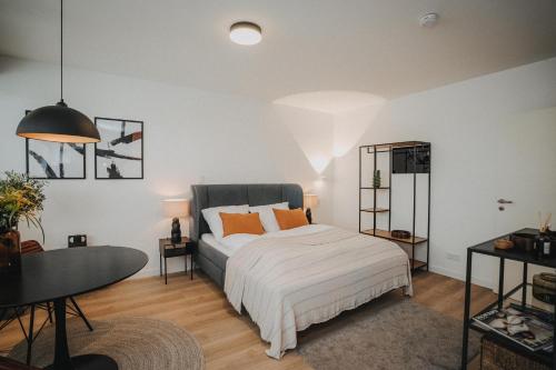 ein Schlafzimmer mit einem Bett mit orangefarbenen Kissen darauf in der Unterkunft DOWNTOWN Apartment mit Luxusbad am Hafen nur 5 Minuten zu Fuß in die Innenstadt! in Oldenburg