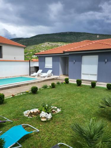 モスタルにあるVila Dolce Vita Mostarの家とスイミングプールのある庭