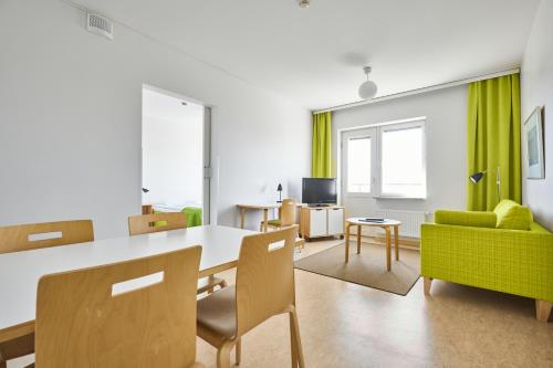 a living room with a table and a green couch at Töölö Towers in Helsinki