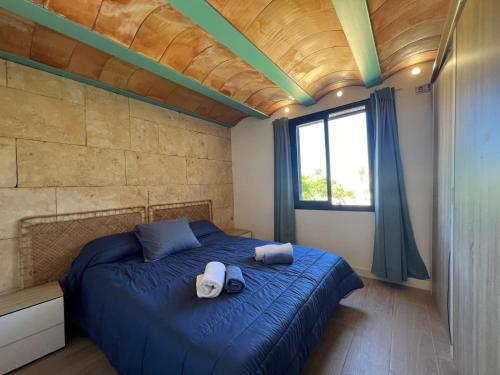 a bedroom with a blue bed with towels on it at La Esquineta de Vientos de Tabarca in Tabarca