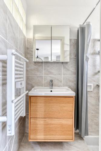 une salle de bain avec un lavabo et un miroir dans l'établissement L'Arche de la Cité avec Netflix Fibre et Clim, à Carcassonne