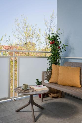 a patio with a bench and a table with a plant at Nido Suite & Apartments in Cesenatico