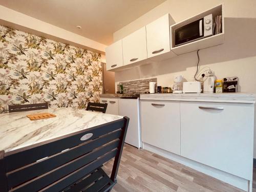 une cuisine avec une table et un comptoir dans l'établissement Tropicana - 297, à Rouen