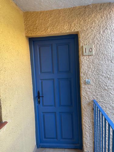 une porte bleue sur le côté d'un bâtiment dans l'établissement T2 Hawaï - Malibu Village, à Canet