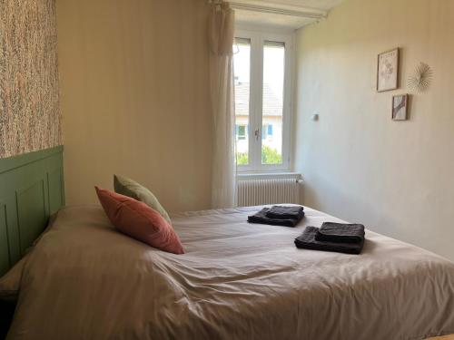 a bedroom with a bed with two towels on it at *La Belle Saison* lumineux, espace de travail, Wifi, Belfort ville in Belfort