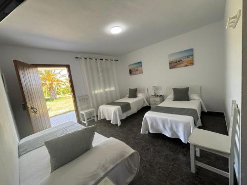 una camera d'albergo con tre letti e una finestra di El Levante a Tarifa