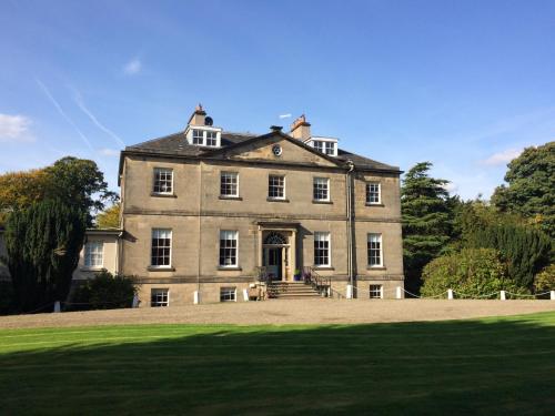 an old house with a large grass field in front at Limefield Mansion House in Livingston