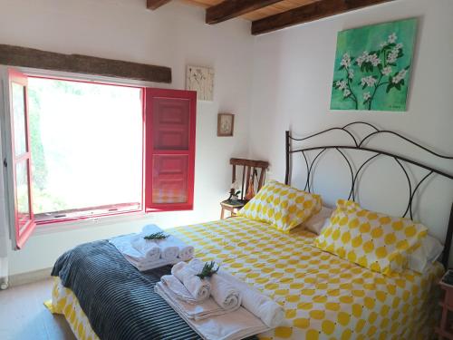 1 dormitorio con 1 cama con toallas en Casa en el campo con piscina en Murcia a 50 kilometros de las playas en La Ñora