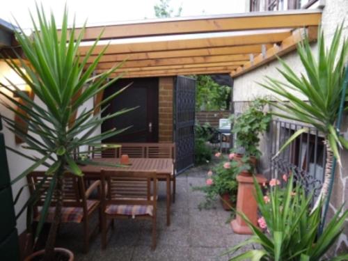 a patio with a wooden pergola and a table and chairs at Ferienwohnung Gisela Schmidt in Amorbach