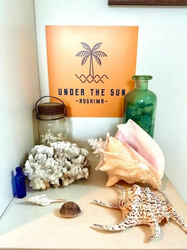 a box of under the sun with shells and a bottle at 青島神社近く 一階貸切 最大六名様まで 暮らすように滞在 in Miyazaki