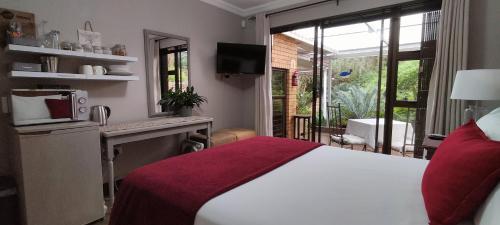 een slaapkamer met een bed en een bureau met een magnetron bij Mountain Gem in Bloemfontein