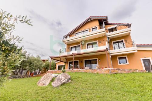 a large yellow house with rocks in the yard at ''Villa Elia'' in Dhíkella