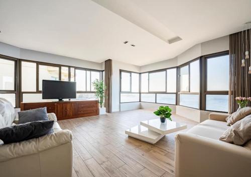 a living room with two couches and a flat screen tv at Seaview Luxury Haven Living & 3Bedrooms Seafront in Sliema