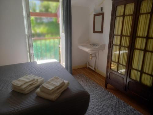two towels on a bed in a room with a window at La maison du jardin in Saint-Jean-de-Luz