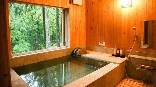 bañera con ventana grande en una habitación en Lupo Forest "GRAN FOREST Echizen Miyama" - Vacation STAY 06371v, en Fukui