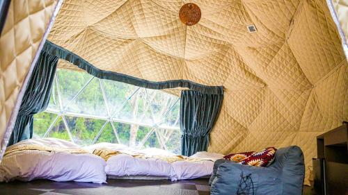 a bed in a room with a large window at Lupo Forest "GRAN FOREST Echizen Miyama" - Vacation STAY 07137v in Fukui