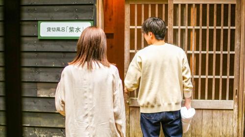 a man and a woman standing in front of a building at Lupo Forest "GRAN FOREST Echizen Miyama" - Vacation STAY 07137v in Fukui