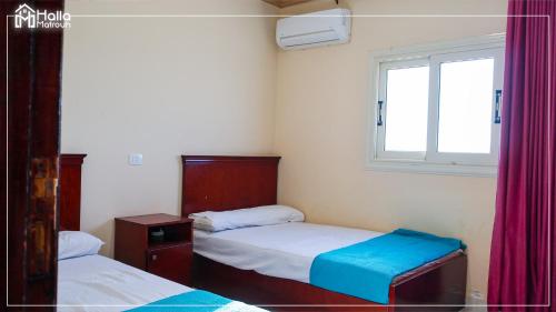 niewielka sypialnia z 2 łóżkami i oknem w obiekcie Halla Matrouh Al Bosphorus w mieście Marsa Matruh