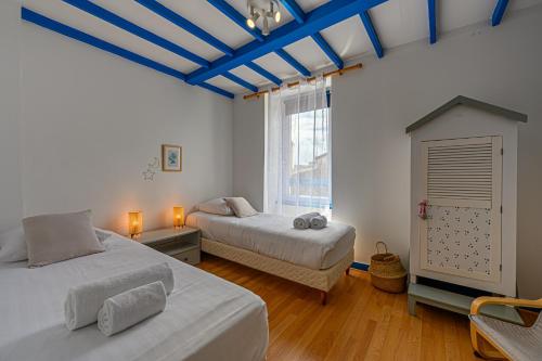 ein Schlafzimmer mit zwei Betten und einer blauen Decke in der Unterkunft La Passante du Sans-Souci - Maison proche plage in Baden