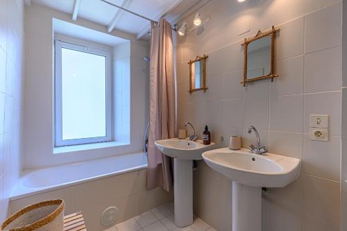 ein Badezimmer mit zwei Waschbecken und einem Fenster in der Unterkunft La Passante du Sans-Souci - Maison proche plage in Baden