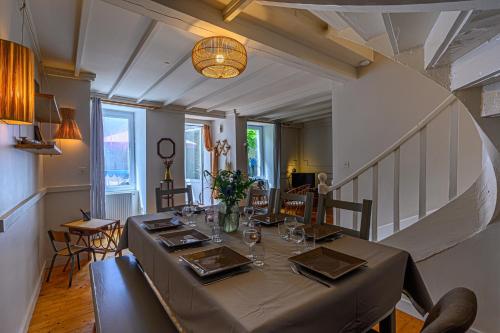 une salle à manger avec une longue table et un escalier dans l'établissement La Passante du Sans-Souci - Maison proche plage, à Baden