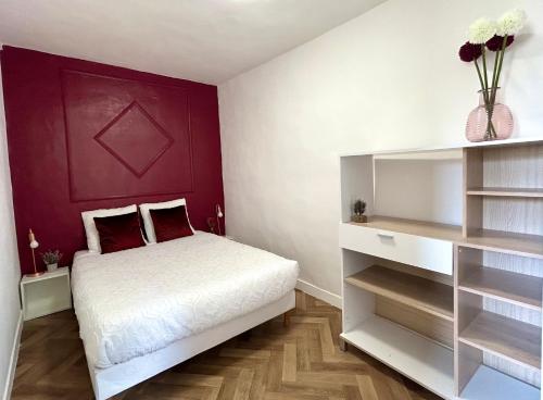 une chambre avec un lit et un mur rouge dans l'établissement Aurore - Château de Versailles - Central, à Versailles
