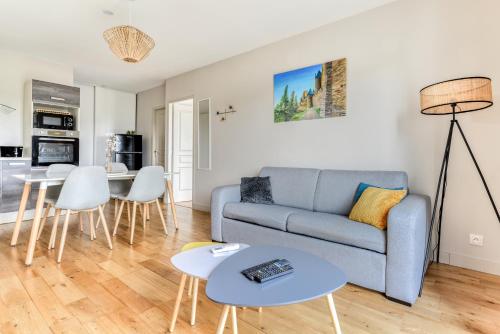 un salon avec un canapé et une table dans l'établissement Le Soleil du Lac - Parking Privatif - Terrasse - Netflix - Clim, à Carcassonne